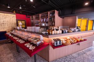 a restaurant with a counter with food on it at Le Siam Hotel Silom Bangkok by PCL in Bangkok