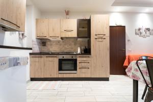 a kitchen with wooden cabinets and a stove at CASE VACANZE ROSA CON SERVIZIO SPIAGGIA in Lido Adriano