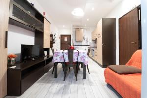a living room with a table and chairs in a room at CASE VACANZE ROSA CON SERVIZIO SPIAGGIA in Lido Adriano +13 photos