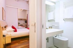 a bedroom with a bed and a sink and a mirror at Rome Central Suite via Vittoria in Rome +160 photos