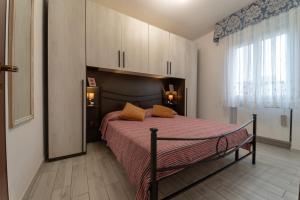 a bedroom with a large bed with orange pillows at CASE VACANZE ROSA CON SERVIZIO SPIAGGIA in Lido Adriano