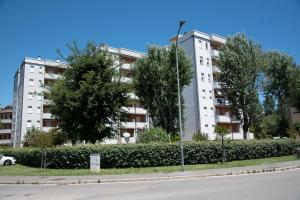 a large white building with trees in front of it at CASE VACANZE ROSA CON SERVIZIO SPIAGGIA in Lido Adriano