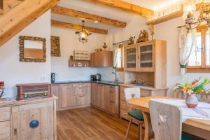 a kitchen with wooden cabinets and a wooden table at Haus Sunnseit'n in Pöllauberg +9 photos