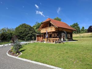 a log cabin with a grass yard in front of it at Haus Sunnseit'n in Pöllauberg