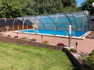 a large swimming pool with a glass house at Landluft in Gnissau