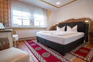 ein Schlafzimmer mit einem Bett, einem Tisch und einem Schreibtisch in der Unterkunft Hotel Wandersleben - Erfurt in Wandersleben