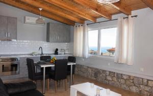 a kitchen and living room with a table and a window at Emilia's Guest House with Sea View Balcony, Stoupa in Stoupa