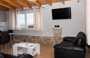 a living room with a couch and a table at Emilia's Guest House with Sea View Balcony, Stoupa in Stoupa