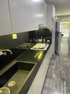a kitchen with a black counter and a sink at Lesnasr chalet apartments in Al ‘Aqabah
