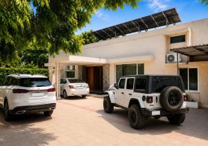 a white jeep parked in front of a house at Royal Palm Villa in Rawalpindi