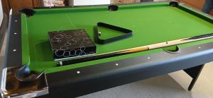 a green pool table with a bat and a baseball at la chambrée in Leschelles