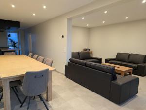 a living room with a table and a couch at La Petite Reine in Bertrix