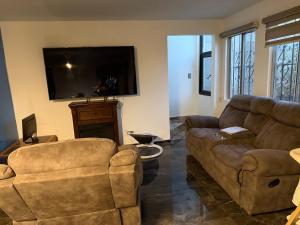 a living room with a couch and a tv at Cabaña Lakshmi in El Pescador