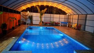 a large swimming pool in a building with an indoor at Paddyfield Inn in Mananthavady