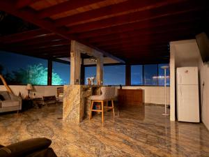 a kitchen and living room with a counter and a refrigerator at Cabaña Lakshmi in El Pescador
