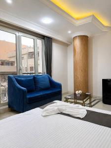 a bedroom with a bed and a blue couch at Egypt Aziz pyramids in Cairo