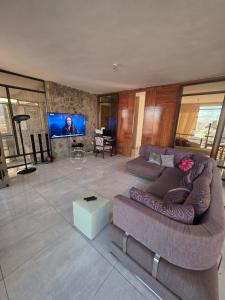 a living room with a couch and a tv at Mosia Guest House in Maseru