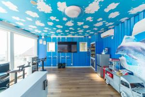 a room with a blue ceiling with clouds painted on it at THE BOXY AWAJI in Awaji