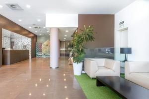 a lobby with a couch and chairs and a table at Sercotel Hola Tafalla in Tafalla