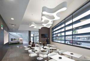 a restaurant with white tables and chairs and a chandelier at Sercotel Hola Tafalla in Tafalla