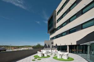 a building with white tables and chairs in front of it at Sercotel Hola Tafalla in Tafalla