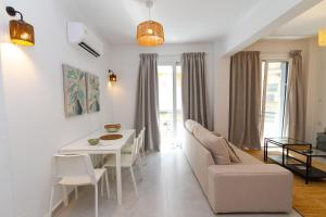 a living room with a white table and a white couch at The Minimal Apartments 3Floors in Loutra Edipsou