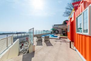 an orange house with a swimming pool and a patio at THE BOXY AWAJI in Awaji