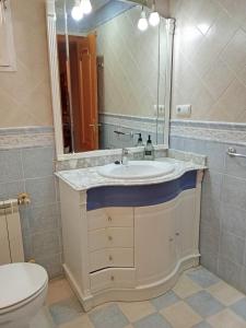 a bathroom with a sink and a toilet and a mirror at Valencia Casa Rosa in Sedaví