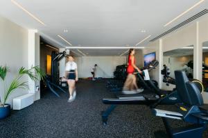 two people walking through a gym with treadmills at Rocabella Santorini Hotel & Spa in Imerovigli