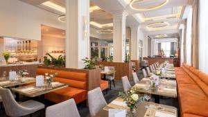 a restaurant with tables and chairs and a bar at Spa & Wellness Hotel Olympia Marienbad in Mariánské Lázně