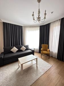 a living room with a black couch and a coffee table at Navruz Hotel Tashkent in Tashkent