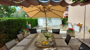 a table with an umbrella on a patio at Apartments Kivi in Novigrad Istria +34 photos