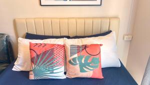 a bed with four pillows on top of it at 1403-304 Saekyung Pool view in Lapu Lapu City