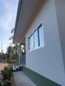 ein Haus mit einem Fenster an der Seite in der Unterkunft Mini House in Koh Samui 