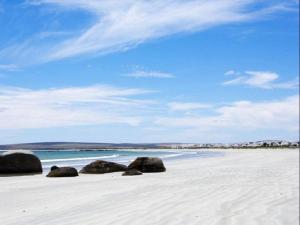 a beach with rocks on the sand and the ocean at Skye in Paternoster
