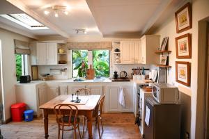 a kitchen with white cabinets and a table and chairs at The Dogbox, Karen in Nairobi