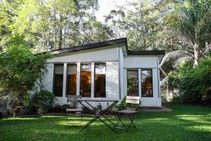 a small white house with a picnic table in the grass at The Dogbox, Karen in Nairobi