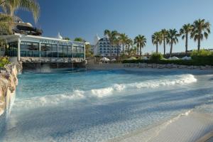 a swimming pool next to a beach with a building at Adalya Elite Lara Hotel - Ultra All Inclusive in Lara