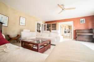 a living room with a white couch and a piano at L'Horizon des Chênes - grand jardin, bbq & table de ping pong in Hagetmau