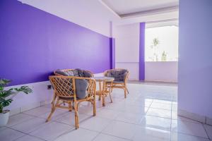 a dining room with two chairs and a table at SANS Vibes Violeta Inn Jambi in Jambi