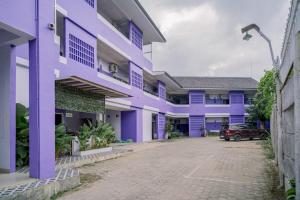 a purple building with a car parked in front at SANS Vibes Violeta Inn Jambi in Jambi