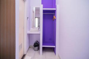 a purple bathroom with a sink and a mirror at SANS Vibes Violeta Inn Jambi in Jambi +34 photos