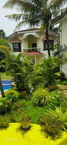a house with trees and plants in front of it at Asif 3 bedroom luxury villa with swimming pool and kitchen in Nagoa-Bardez