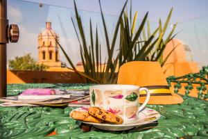 墨西哥城的住宿－特姆普羅市長酒店，一张桌子,上面放着一盘饼干和一杯咖啡杯