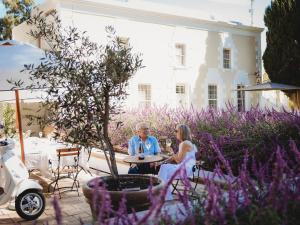 a man and a woman sitting at a table in a garden at Paul René Manor House in Robertson