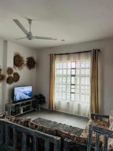 a living room with a tv and a window at Atieno home in Kwale