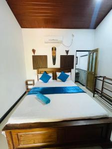 a bedroom with a large bed with blue pillows at Angry birds rooms in Habarana