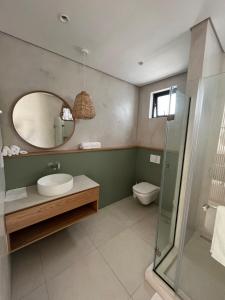 a bathroom with a sink and a mirror and a toilet at Exclusive beachfront penthouse in Belle Mare +13 photos