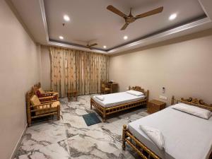 a bedroom with two beds and a ceiling fan at Iskcon guest house in Patna