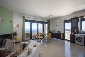 a living room with a couch and a table with chairs at Sea View Apartment in Rhodes Town